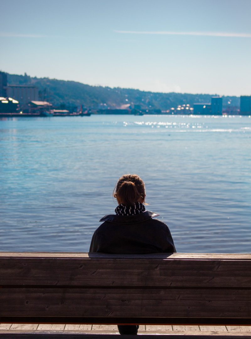 Kvinne ser utover Oslofjorden fra Aker brygge.