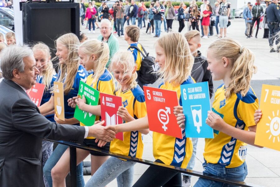 jenter som holder plakater med bærekraftsmålene