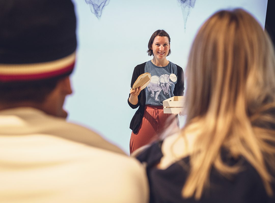 dame i en undervisningssituasjon med to elever med ryggen til