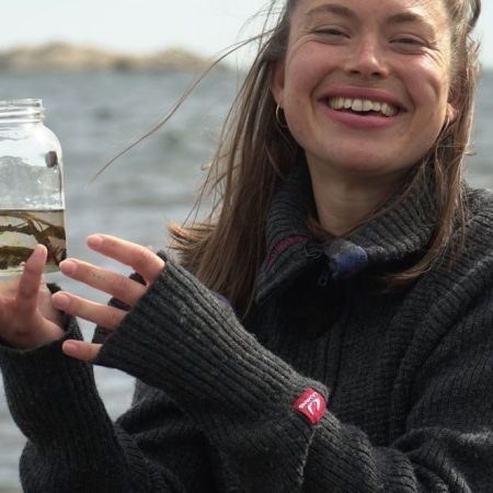 jente som holder frem en vannprøve - hav og klima