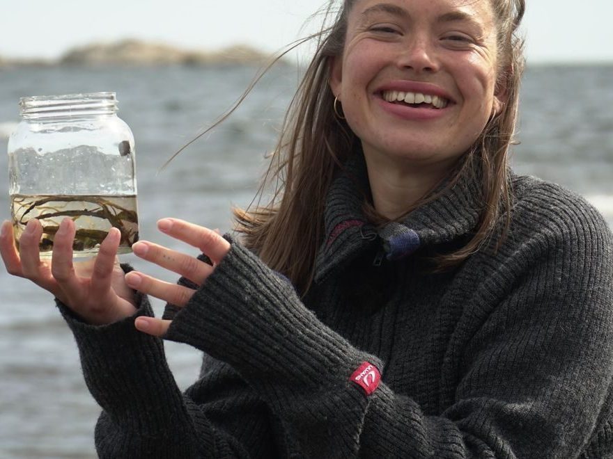 jente som holder frem en vannprøve - hav og klima